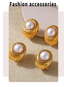 Detail of vintage gold textured earrings with large white pearls on a neutral fabric