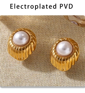 Close-up of vintage PVD plated gold earrings with pleated texture and white pearl center