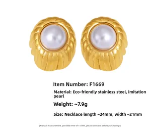 Close-up of elegant gold ribbed earrings with white faux pearl in stainless steel