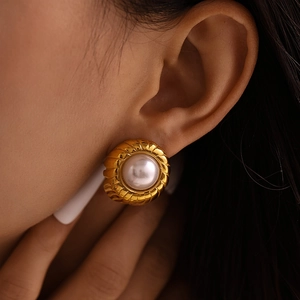 Elegant French vintage gold spiral earrings with white pearl inlay worn by a woman