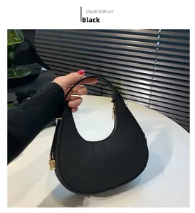 Close-up of black stone-pattern crescent shoulder bag with golden zipper and metal buckles