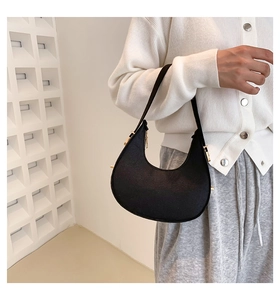 Detail of a black crescent hobo bag with adjustable gold buckle on the shoulder strap