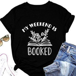 Black T-shirt with MY WEEKEND IS BOOKED text and floral book illustration laid with accessories