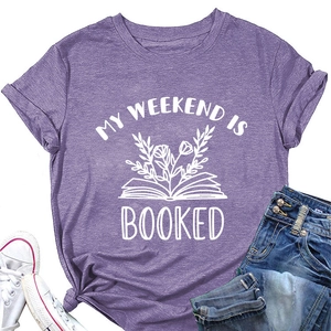 Flat lay of purple cotton T-shirt featuring My Weekend is Booked graphic with book and flowers