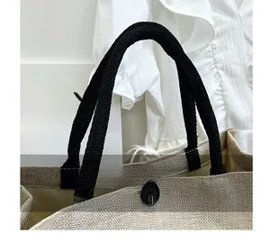 Detail of burlap tote bag with sturdy black rope handle and secure button closure