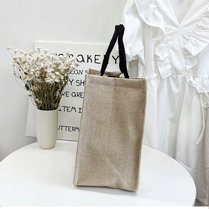Detail of eco-friendly linen tote bag showing rustic jute texture and black woven handles