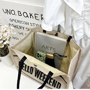 Spacious linen tote bag with HELLO WEEKEND print holding books and an umbrella