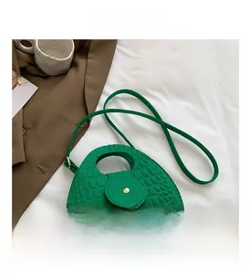 Détail de la texture crocodile vert émeraude sur le sac à main selle pour femme
