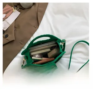 Détail de l'intérieur d'un sac à bandoulière en feutre vert montrant sa grande capacité