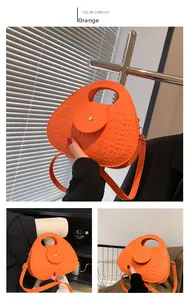 Détail du sac orange à motif crocodile avec poignée ronde et bandoulière réglable