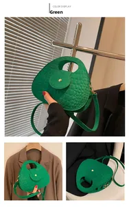 Détail du sac à main vert à motif crocodile avec poignée demi-lune et fermoir doré chic
