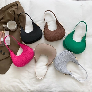 Chic solid color crescent hobo bags in assorted colors and textures displayed on fabric