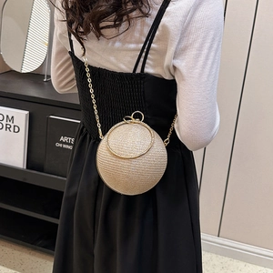 Détail d'un sac de soirée sphérique doré avec strass et poignée anneau métallique