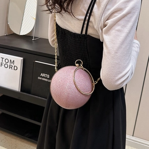 Détail du sac de soirée sphérique rose brillant avec poignée anneau dorée et chaîne