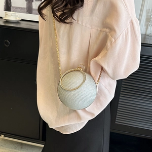 Détail d'un sac de soirée sphérique argenté en strass avec anse anneau dorée