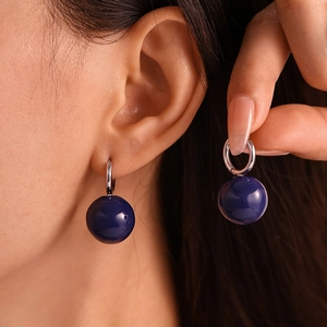 Orecchini a sfera in smalto blu scuro con cerchi in acciaio inossidabile lucido su modella