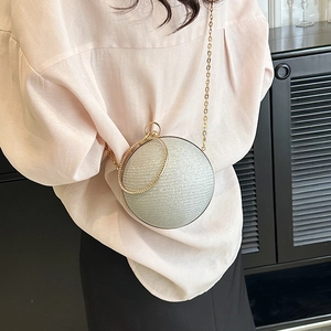 Détail du sac de soirée sphérique argenté avec fini pailleté et poignée anneau strass