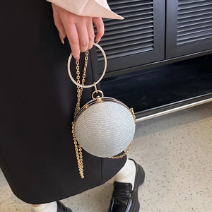 Détail d'un sac de soirée sphérique argenté avec strass et poignée en métal