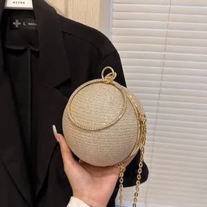 Détail du sac de soirée sphérique doré avec strass, poignée anneau et chaîne en métal