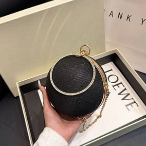 Détail d'un sac de soirée noir sphérique avec paillettes et poignée anneau en cristal