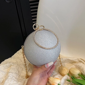 Détail d'une minaudière sphérique argentée scintillante avec poignée anneau strass