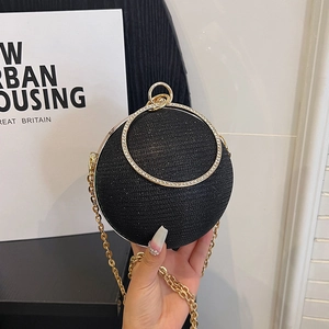Détail du sac de soirée noir avec strass, poignée dorée et fine chaîne en métal