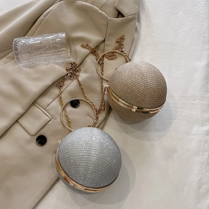 Détail de sacs de soirée sphériques dorés et argentés avec anneaux en strass et chaînes
