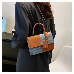 Detail of color-block square bag showing blue tweed and brown leather texture