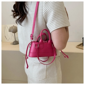 Magenta mini shell handbag with drawstring lining shown on model in home setting