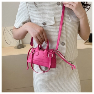 Close-up of rose pink mini crossbody bag with drawstring design and fashion lettering
