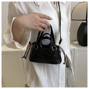 Detail of black mini crossbody shell bag with double handles and embossed fashion text