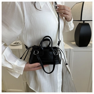 Detail of a black mini shell bag with drawstring closure and fashion logo embossing