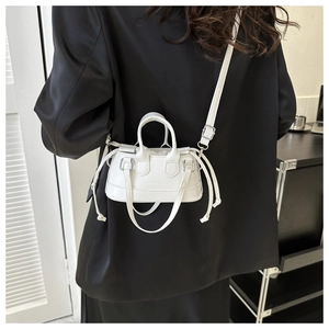 Detail of white leather mini bucket bag with fashion lettering and adjustable strap