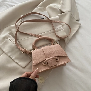 Detailed macro of pink lychee leather mini square bag with elegant handle and buckle decoration
