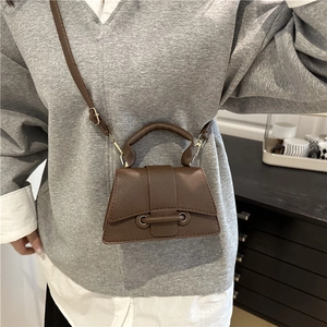 Detail of a brown lychee pattern mini crossbody bag with a unique hourglass shape