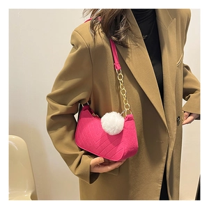Detail of rose pink textured crossbody bag with V-quilted pattern and fluffy pompom