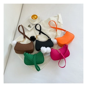Detailed overhead view of quilted crossbody bags in five colors with pompom charms
