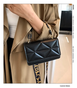 Detail of black geometric quilted crossbody bag with gold chain and wide logo strap