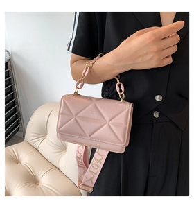 Detail of pink quilted handbag showing acrylic chain and patterned wide shoulder strap