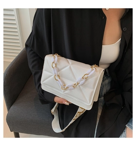 Detail of white geometric quilted bag with thick acrylic chain and wide fabric strap