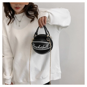 Détail d'un sac à main noir en forme de basket avec chaîne dorée et texte blanc