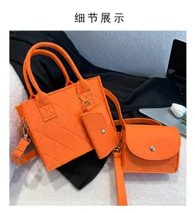 Detail view of orange felt tote bag set with diamond quilting and gold hardware