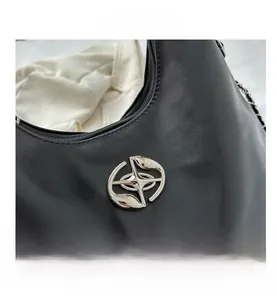 Detail of black hobo bag with silver metallic logo hardware and decorative chain strap