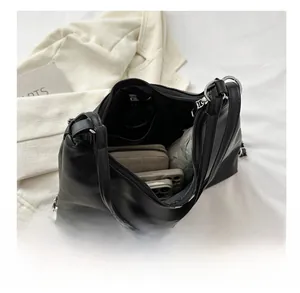 Spacious interior of a black leather tote bag showing storage for phone and wallet