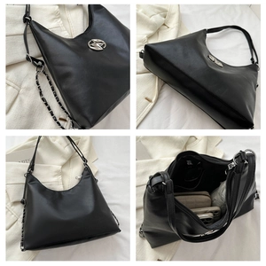 Detail of black hobo bag with round metal buckle and composite chain shoulder strap