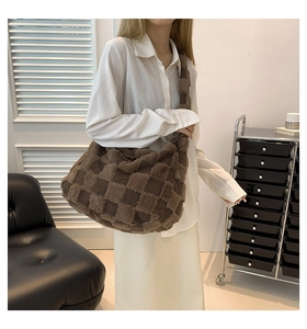 A stylish brown checkerboard patterned fleece tote bag displayed on a female model