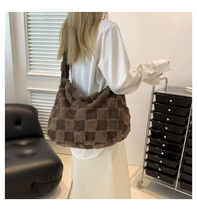 Close-up of brown checkerboard plush texture and wide strap on hobo shoulder bag
