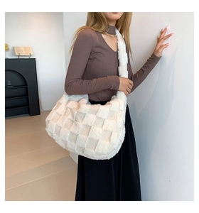 Detail of soft cream plush tote bag with checkered texture and wide shoulder strap