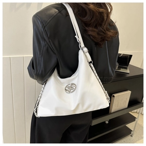 Close-up of white nylon shoulder bag with silver logo and chain strap on model