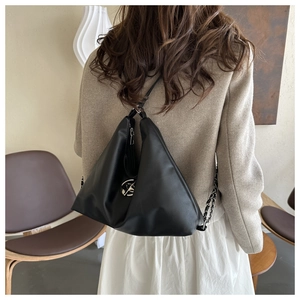 Detailed view of black PU leather shoulder bag with chain strap on a model shoulder